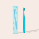 Blue toothbrush with packaging labeled 'Cocolab Kids' on a beige background