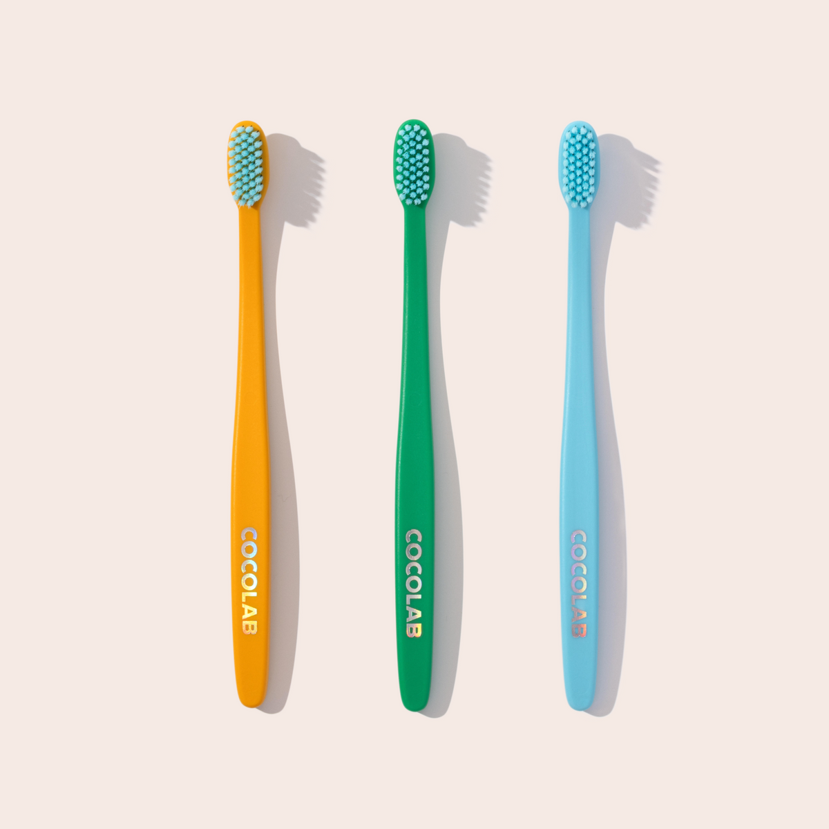 Three colorful toothbrushes with 'Cocolab' branding on a light background
