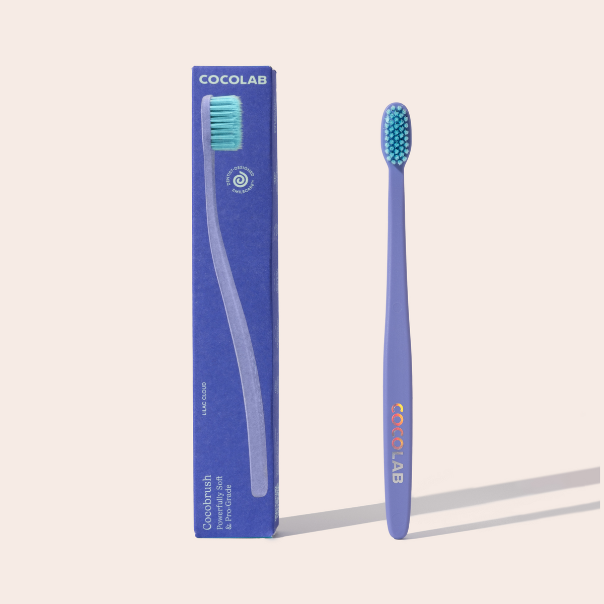 Blue toothbrush with Cocolab branding next to its packaging on a light beige background
