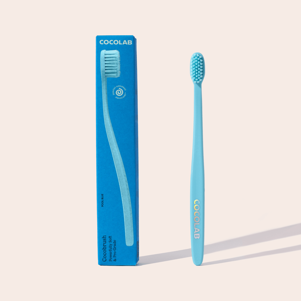 Blue toothbrush with packaging labeled 'Cocolab' on a beige background