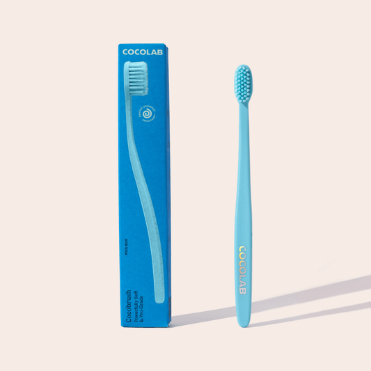 Blue toothbrush with packaging labeled 'Cocolab' on a beige background