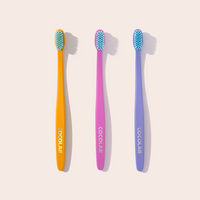 Three colorful toothbrushes with 'COCOLAB' branding on a light background