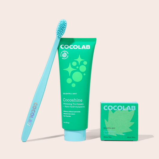 Cocolab toothpaste tube and toothbrush with packaging on a light beige background