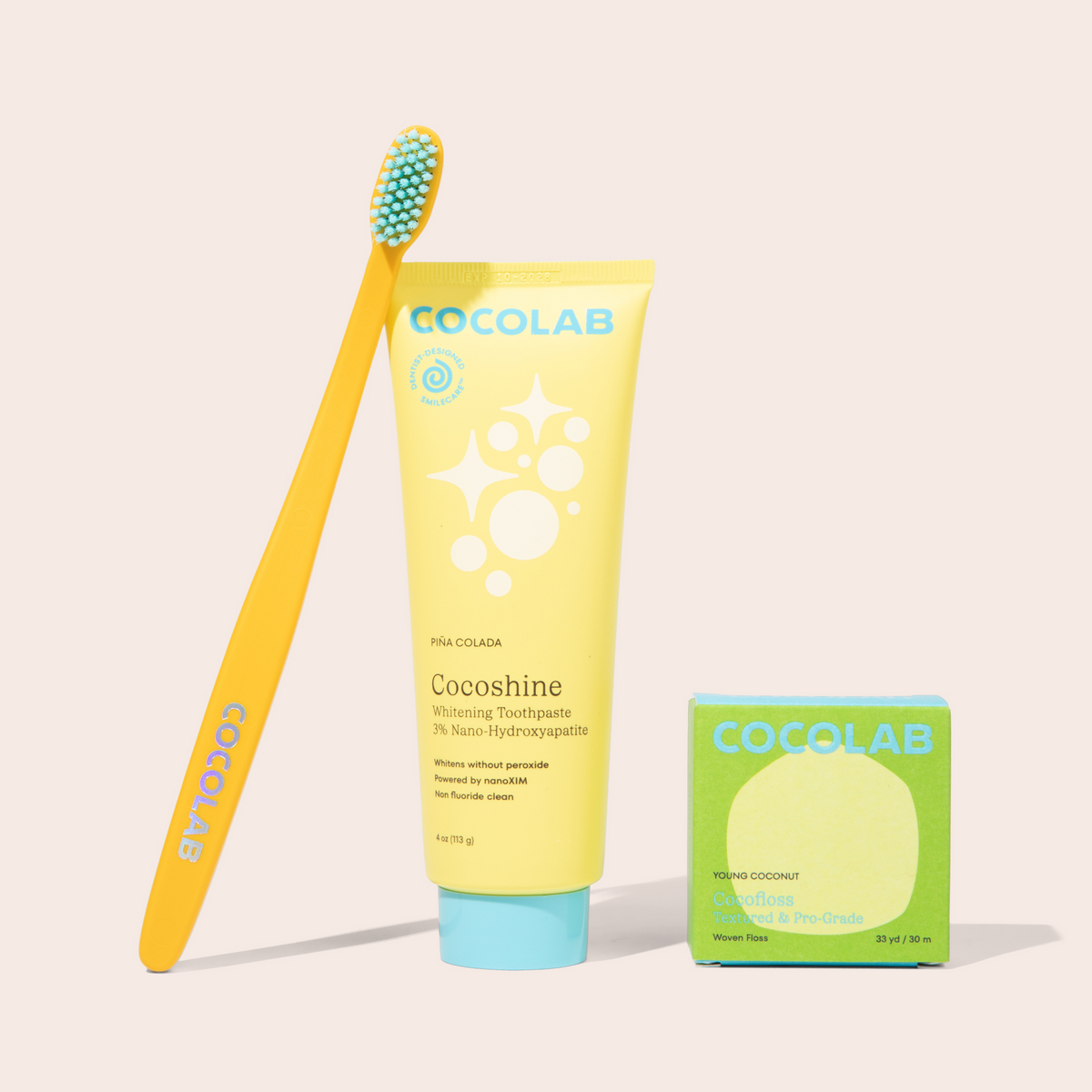 Cocolab toothbrush and toothpaste tube on a light beige background