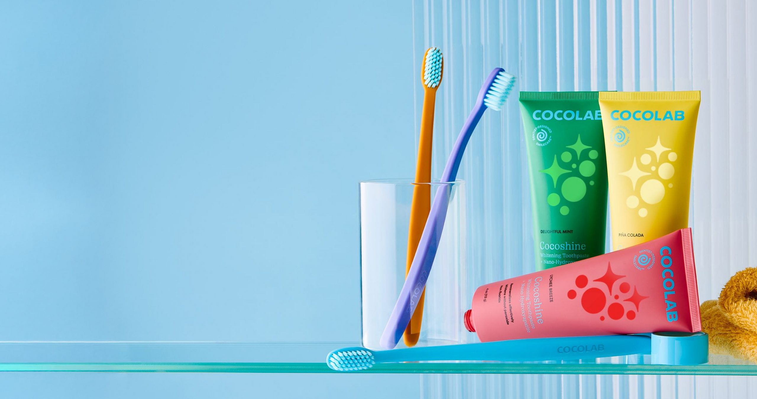 Cococare toothbrush, toothpaste, and dental floss on a blue background