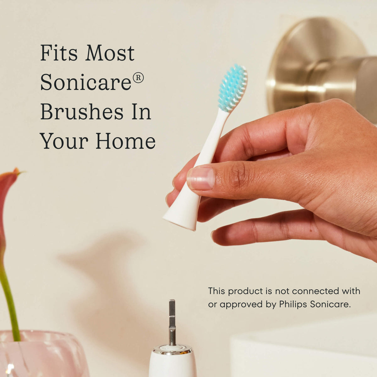 White electric toothbrush handle with a blue brush head on a wooden surface, with text about compatibility with Sonicare brushes.
