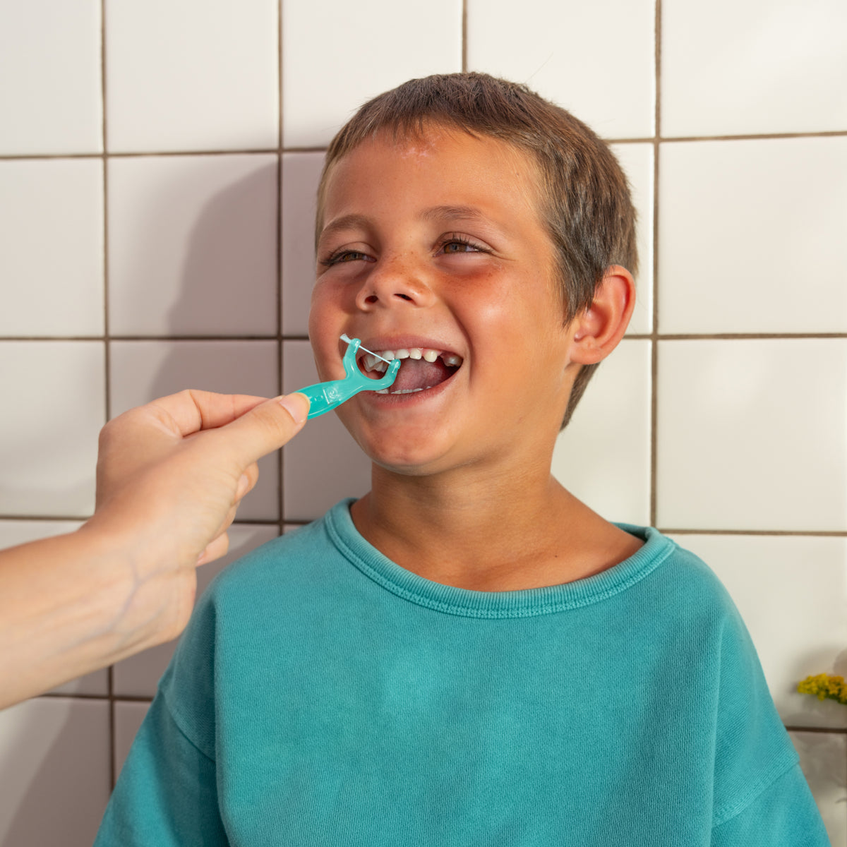 A child having their teeth flossed with the Kid's Reflosser