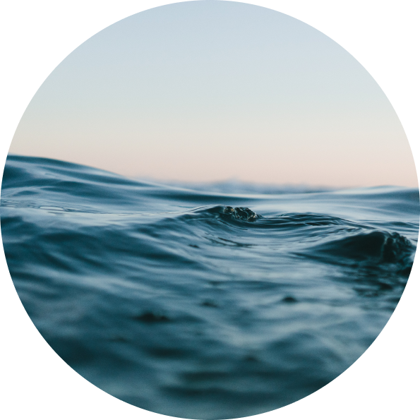 Circular image of ocean waves with a soft gradient sky.