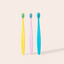 Three colorful toothbrushes on a light beige background